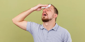 young man wiping forehead with a napkin