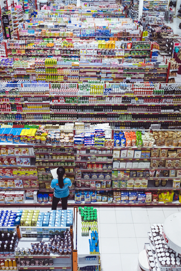 Shopper browsing rows of personal-care products in a supermarket