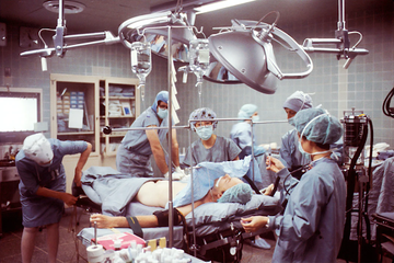 Medical team performing surgery in an operating room while wearing scrubs