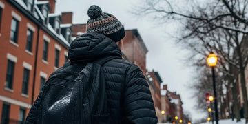 Active commuter walking uphill in winter showing how back sweat builds under jackets.