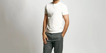 A man standing wearing neat apparel sweat proof undershirt in a gray background
