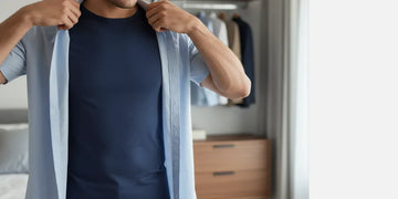 Man adjusting a moisture-wicking undershirt underneath a dress shirt to show layering benefits.