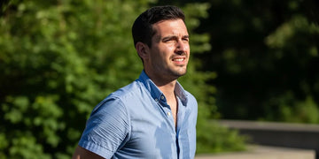 Man feeling uncomfortable as sweat makes his shirt cling in warm weather.