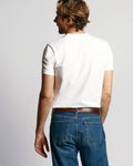 Rear view of Sweat Defender V-Neck Undershirt 4-Pack showcasing a white short-sleeve design on a model against a gray background
